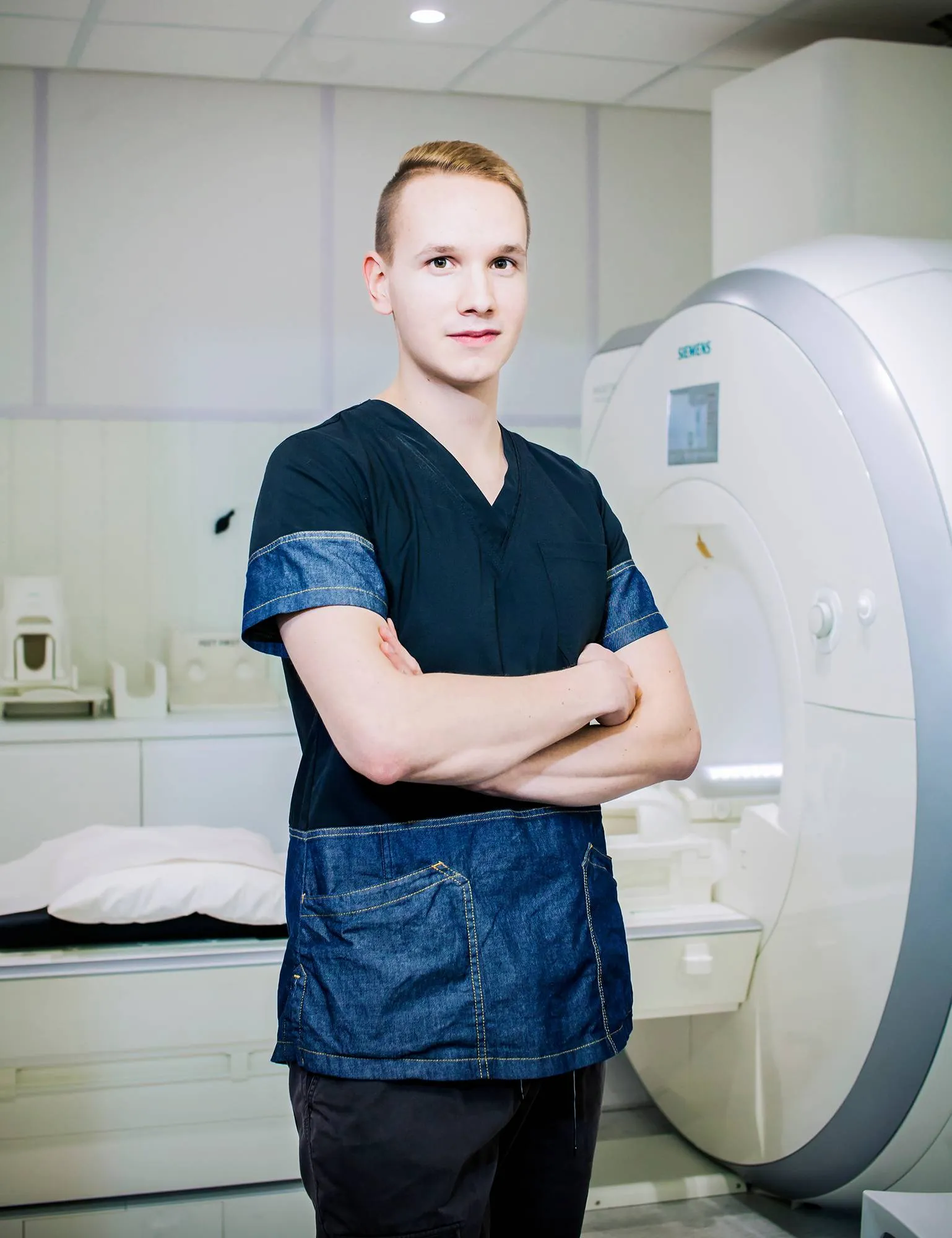 Magneettihoitaja Joel Salonen ja hänen työkalunsa, magneettikuvauslaite, Helsingin Pohjola Sairaalassa.