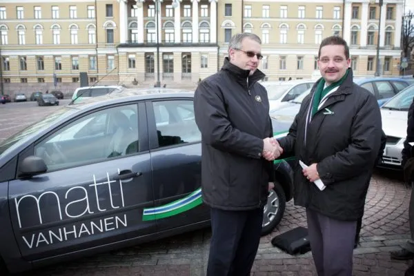 LKS 20051118 HELSINKI - VANHANEN - PRESIDENTINVAALIKAMPANJA: Matti Vanhasen presidentinvaalikampanjan käyttöön otettavista sadasta henkilöautosta luovutettiin ensimmäinen 30 kpl erä autoja kampanjatyöntekijöille perjantaina Helsingin Senaatintorilla. Autot ovat Ford Focus -merkkisiä ja ne on teipattu Matti Vanhasen Vihreä Tuuli -kampanjaväreihin. Oululaisen autoliike Viescar Oy:n toimitusjohtaja Pekka Kimpimäki (vas) luovutti autot kampanjapäällikkö Jari Flinckille. LEHTIKUVA / HEIKKI SAUKKOMAA