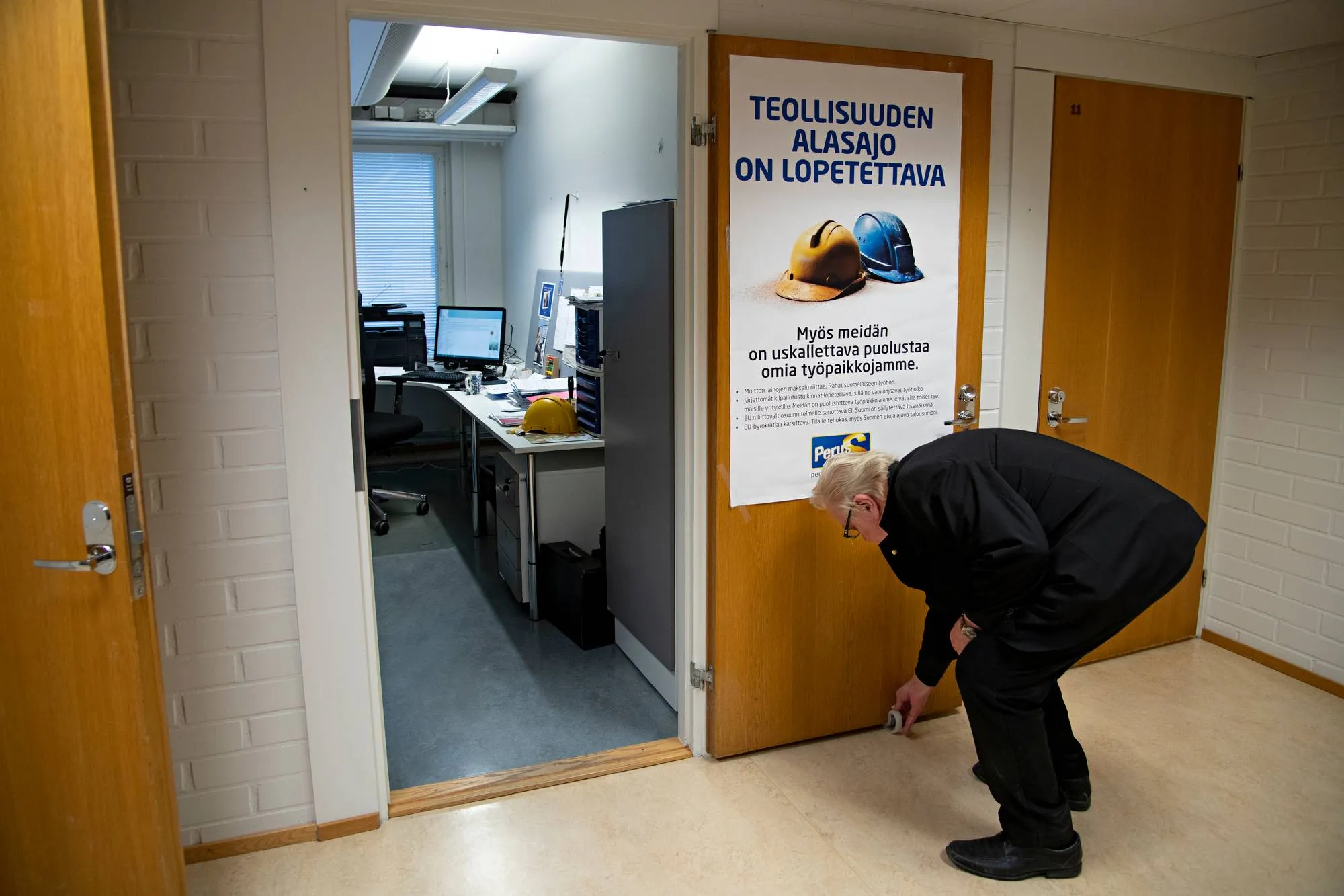 Matti Putkonen puheenjohtaja Jussi Halla-ahon työhuoneen edustalla.