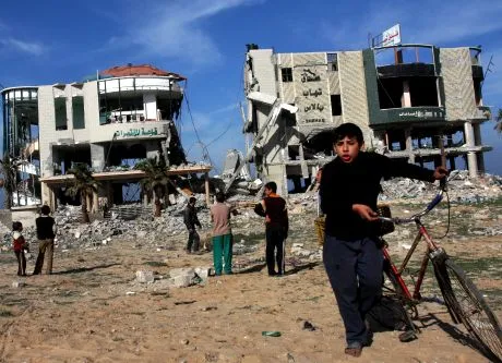 Palestinian children gather around the remains of the Jazeera hotel destroyed in Israeli military operations in Gaza City, Tuesday, Jan. 13, 2009. Israeli troops advanced into Gaza suburbs for the first time early Tuesday, residents said, hours after Prime Minister Ehud Olmert warned Islamic militants that they face an "iron fist" unless they agree to Israeli terms for an end to war in the Gaza Strip. (AP Photo/Khalil Hamra)