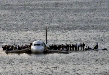 Airline passengers wait to board a ferry to be rescued on the wings of a US Airways Airbus 320 jetliner that safely ditched in the frigid waters of the Hudson River in New York, Thursday Jan. 15, 2009 after a flock of birds knocked out both its engines. All 155 people on board survived. (AP Photo/Steven Day)